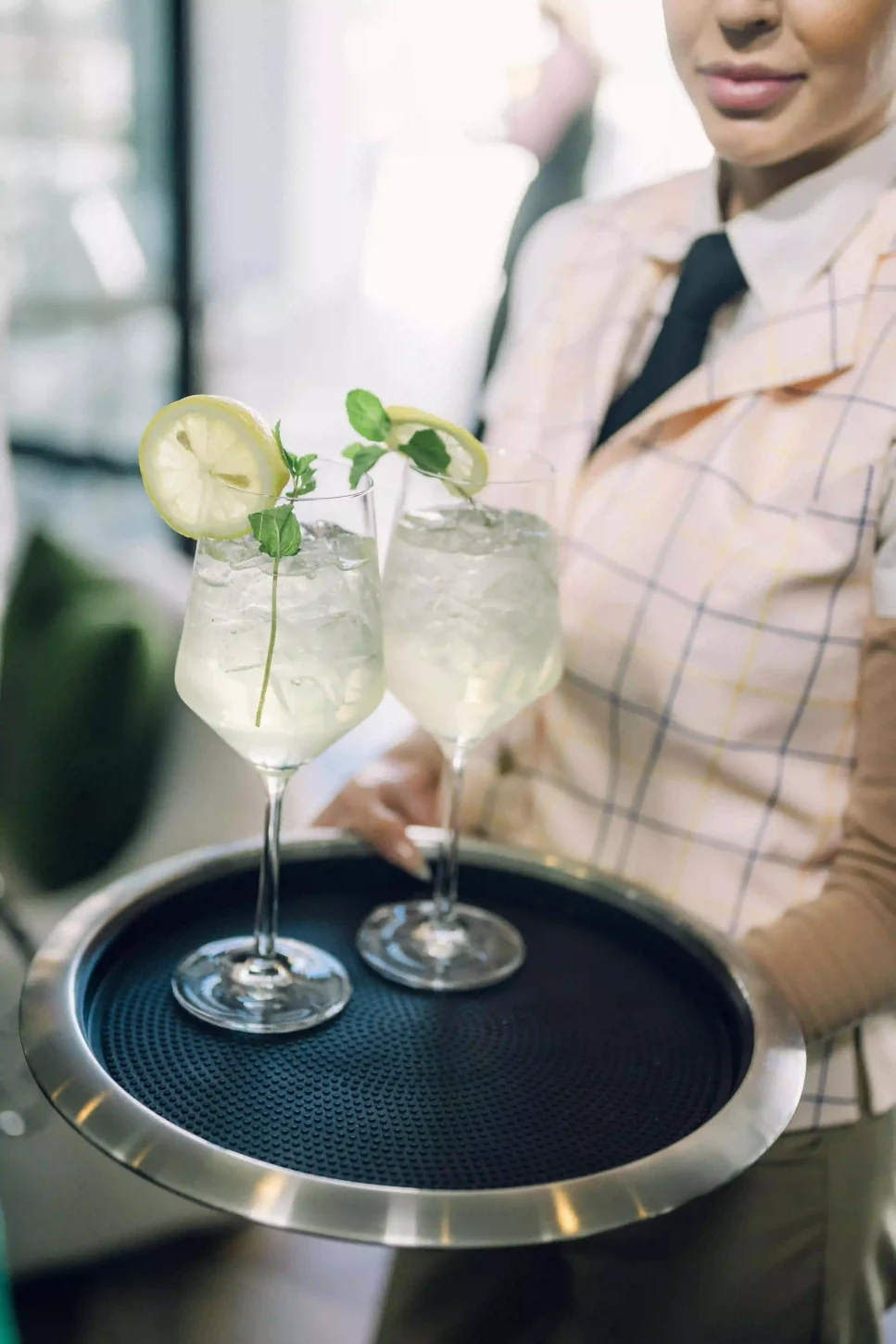 Waitress presenting two cocktails on a tray