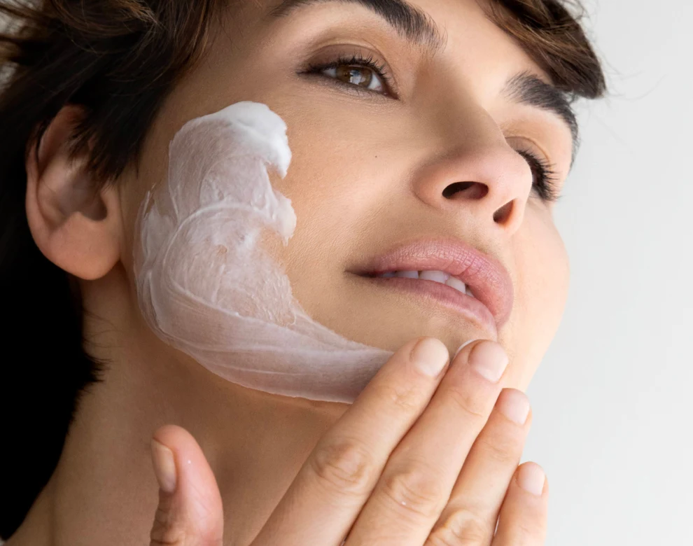 Woman massaging her face with cream