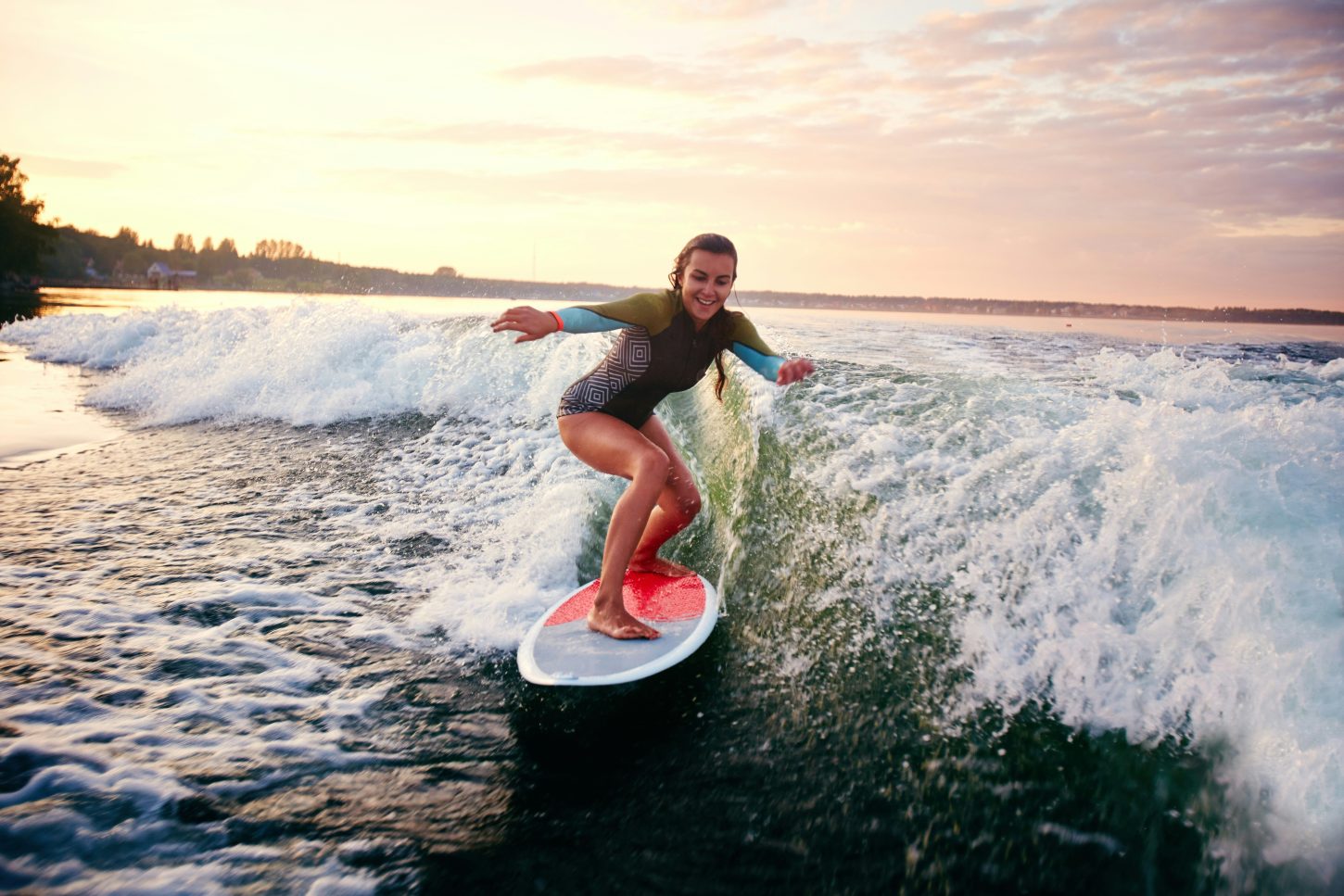 Girl surfing a wave at sunset.